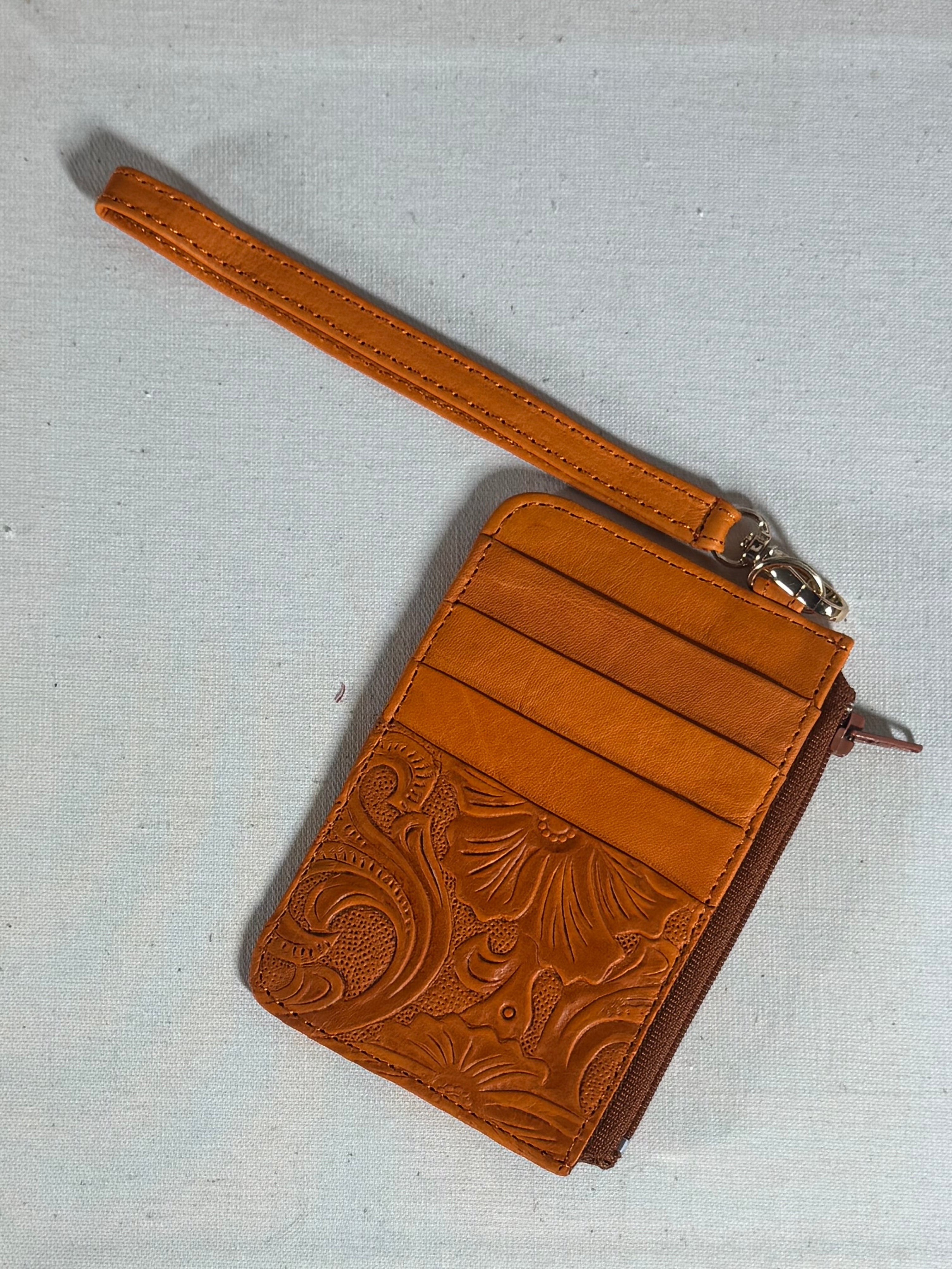 Camel leather wallet with embossed design on a textured surface