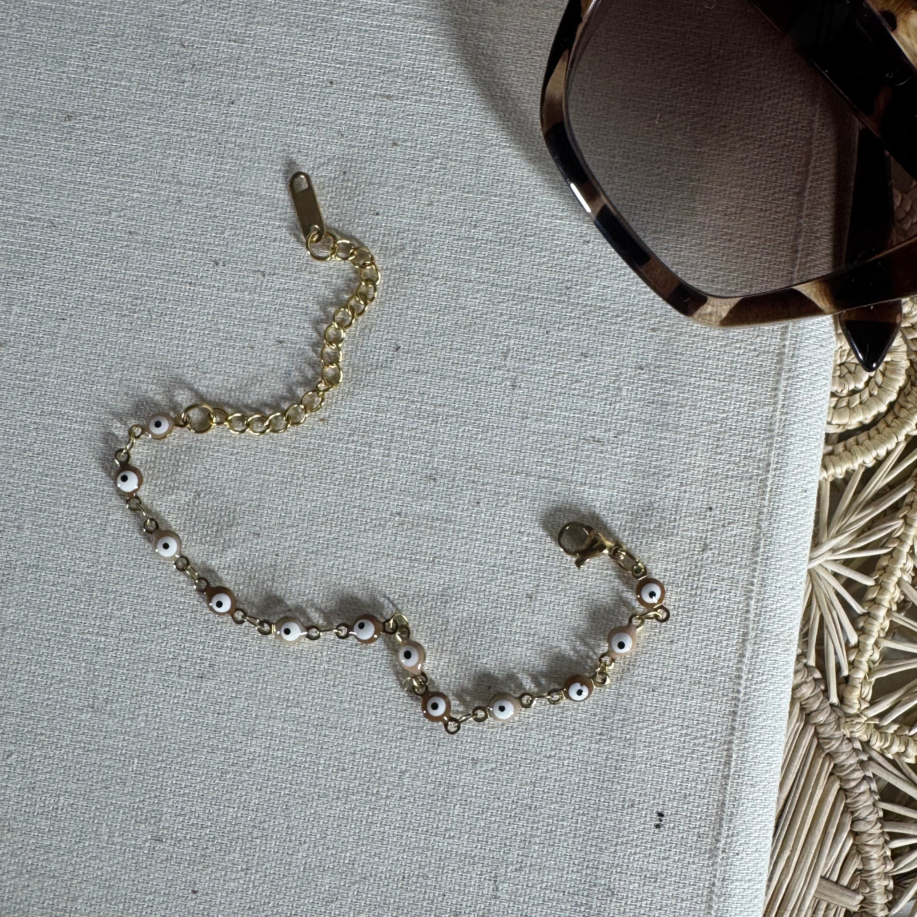 Gold chain bracelet with small beads on a textured surface